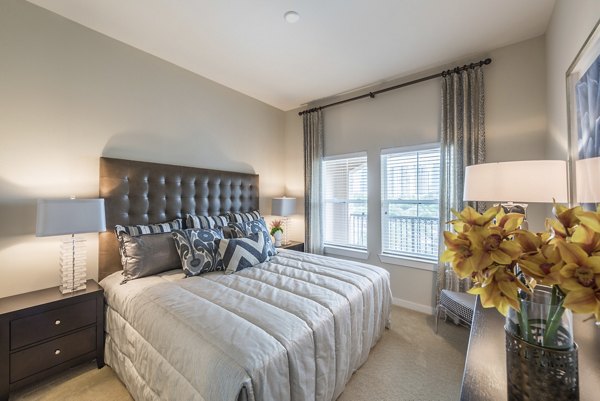 Bedroom featuring modern decor and abundant natural light at High Point Uptown Apartments