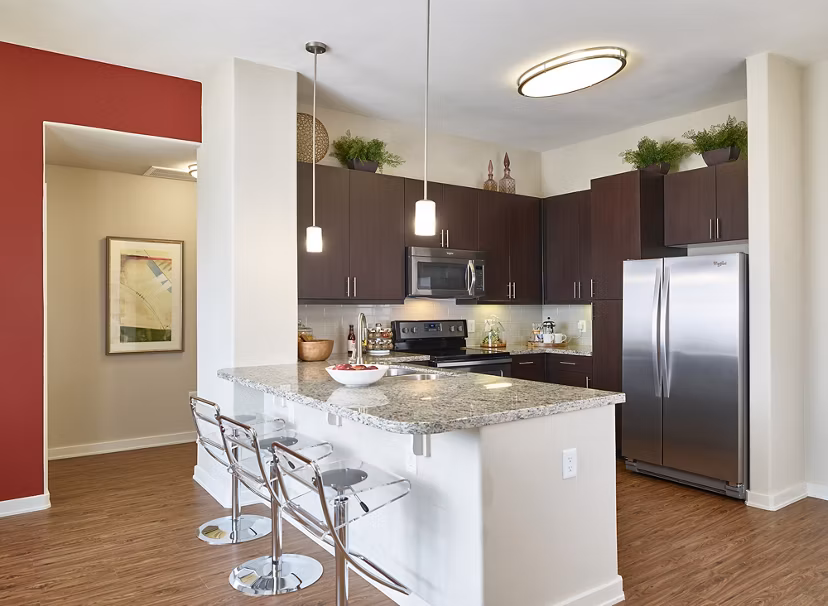 Modern kitchen featuring stainless steel appliances and granite countertops at High Point Uptown Apartments