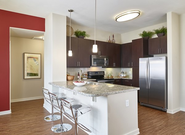 Modern kitchen featuring stainless steel appliances and granite countertops at High Point Uptown Apartments