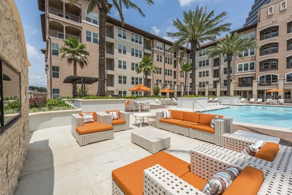 Luxury pool with sun loungers and city views at High Point Uptown Apartments