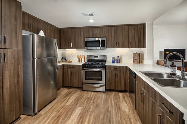 Modern kitchen with stainless steel appliances at The Heights at Chino Hills Apartments, offering luxury living space