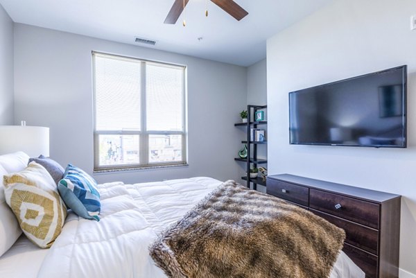Elegant bedroom with plush bedding and large windows at Overture Central Park Apartments, a Greystar luxury community