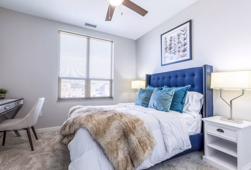 Bedroom featuring modern furnishings and large windows at Overture Central Park Apartments