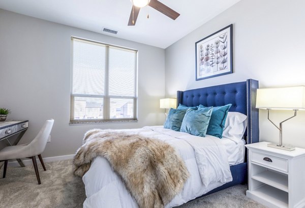 Bedroom featuring modern furnishings and large windows at Overture Central Park Apartments