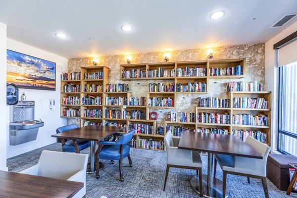 Clubhouse library with cozy seating and modern dÃ©cor at Overture Central Park Apartments