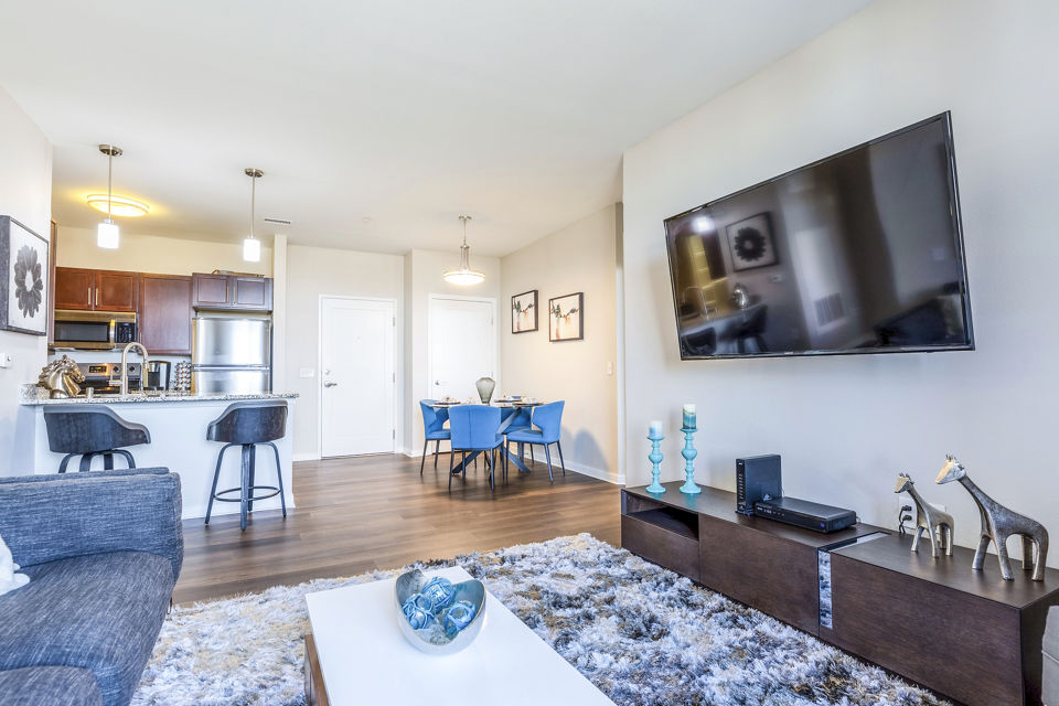 Modern living room with cozy seating and large windows at Overture Central Park Apartments