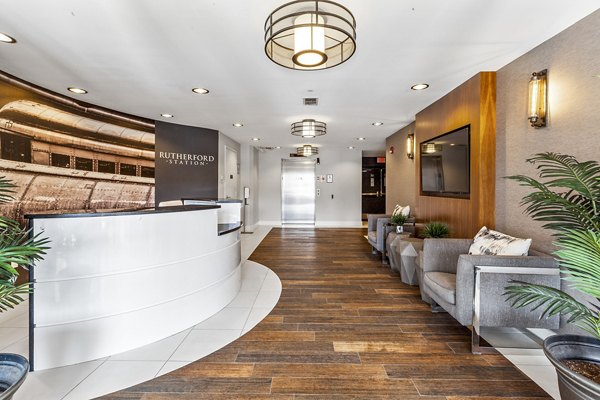 Welcoming lobby with modern design at Rutherford Station Apartments, featuring comfortable seating and sleek front desk