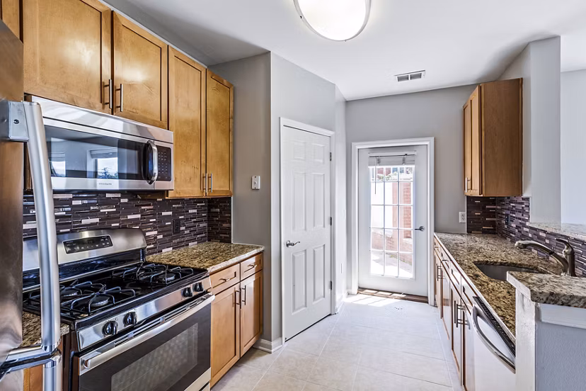 Contemporary kitchen with stainless steel appliances in Rutherford Station Apartments