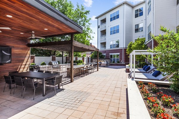 Grill station with modern outdoor seating at Rutherford Station Apartments, ideal for social gatherings and relaxation in a luxury setting