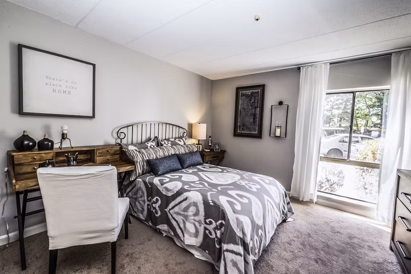 Cozy bedroom with natural light at Avana Weymouth Apartments, featuring plush bedding and modern furnishings