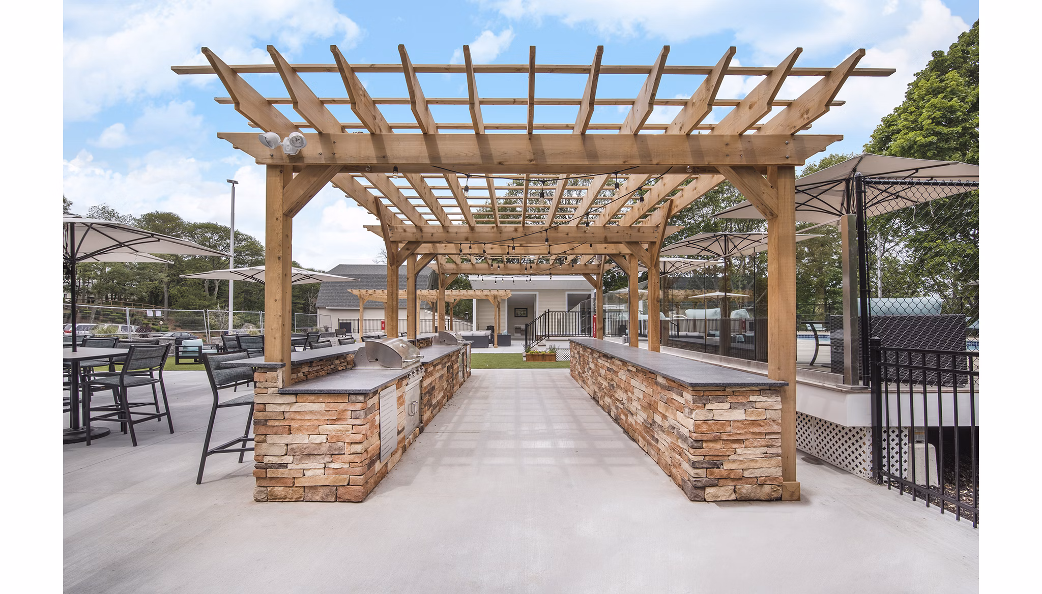Outdoor BBQ grill area with modern seating at Avana Weymouth Apartments