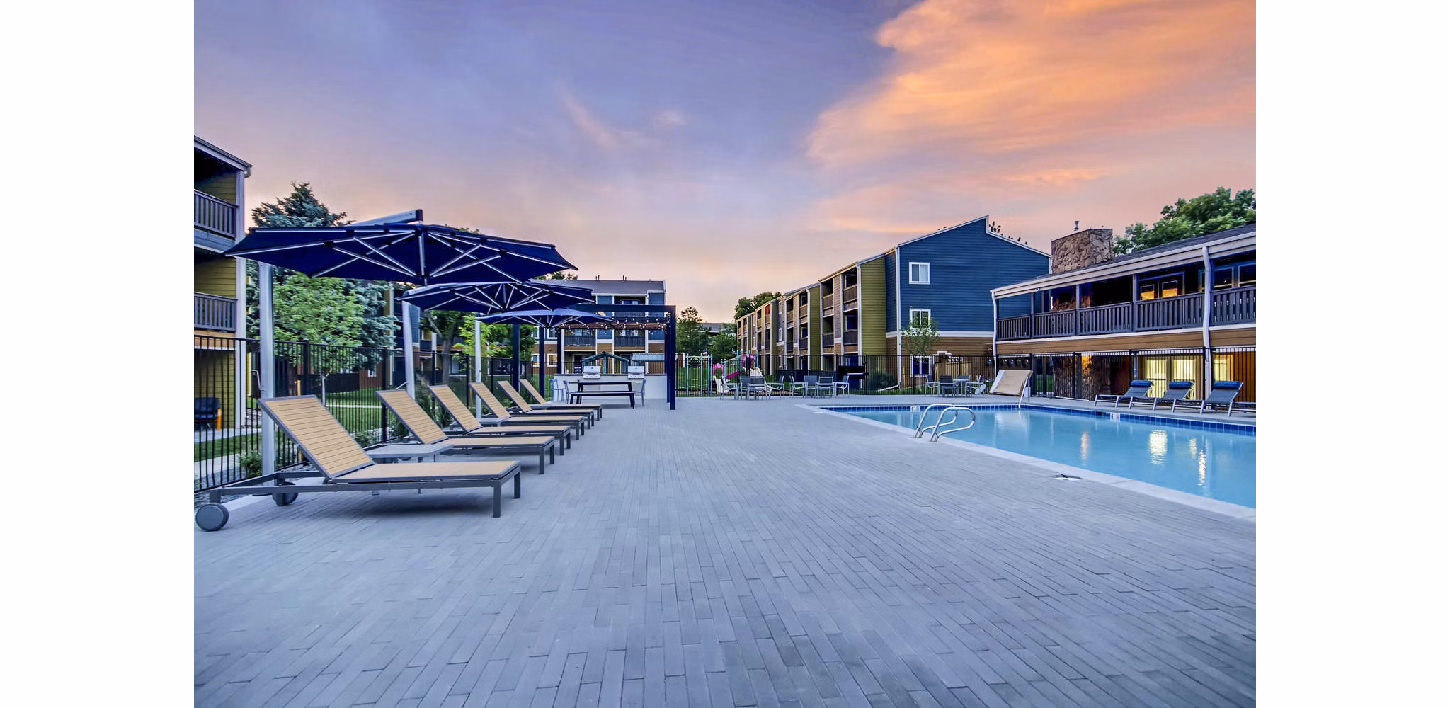 Spacious outdoor pool area at Park Place at 92nd Apartments with lounge chairs and landscaped surroundings