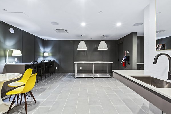 Living room with large bookshelf, TV, and seating area at The Chelsea Apartments