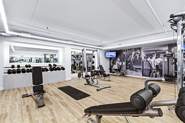 Well-equipped gym with various exercise machines and free weights at The Chelsea Apartments