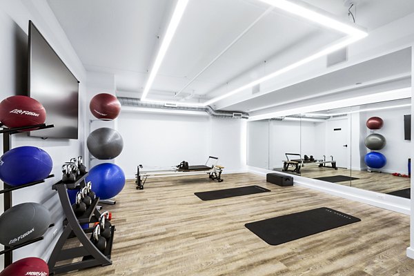 Well-equipped gym with exercise balls, weights, and rowing machines at The Chelsea Apartments