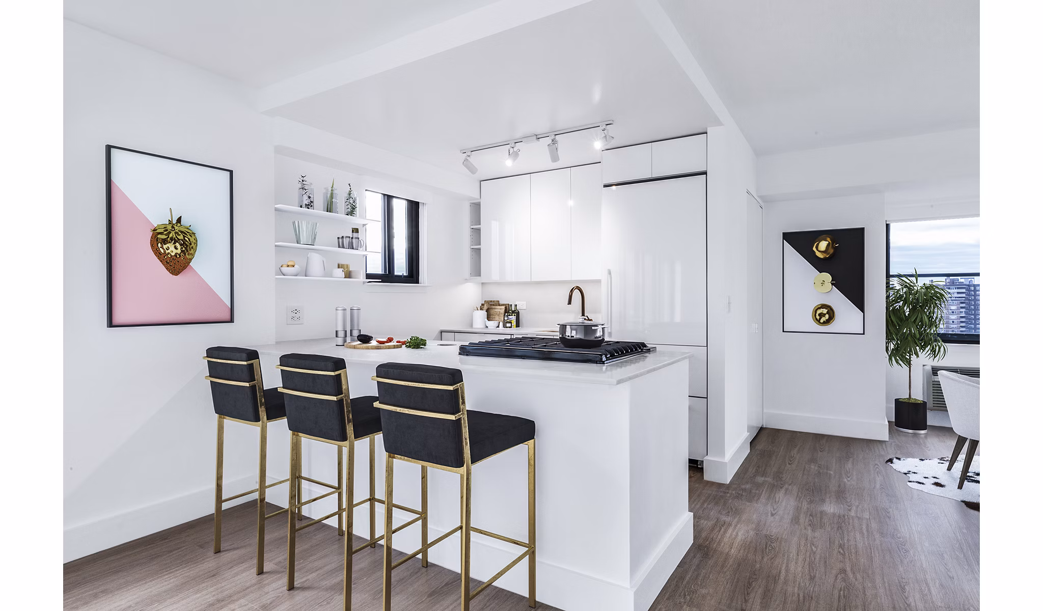 Sleek white kitchen with bar stools and wooden flooring at The Chelsea Apartments