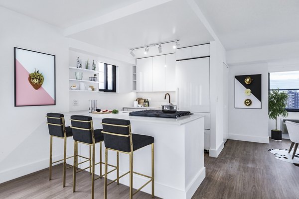 Sleek white kitchen with bar stools and wooden flooring at The Chelsea Apartments