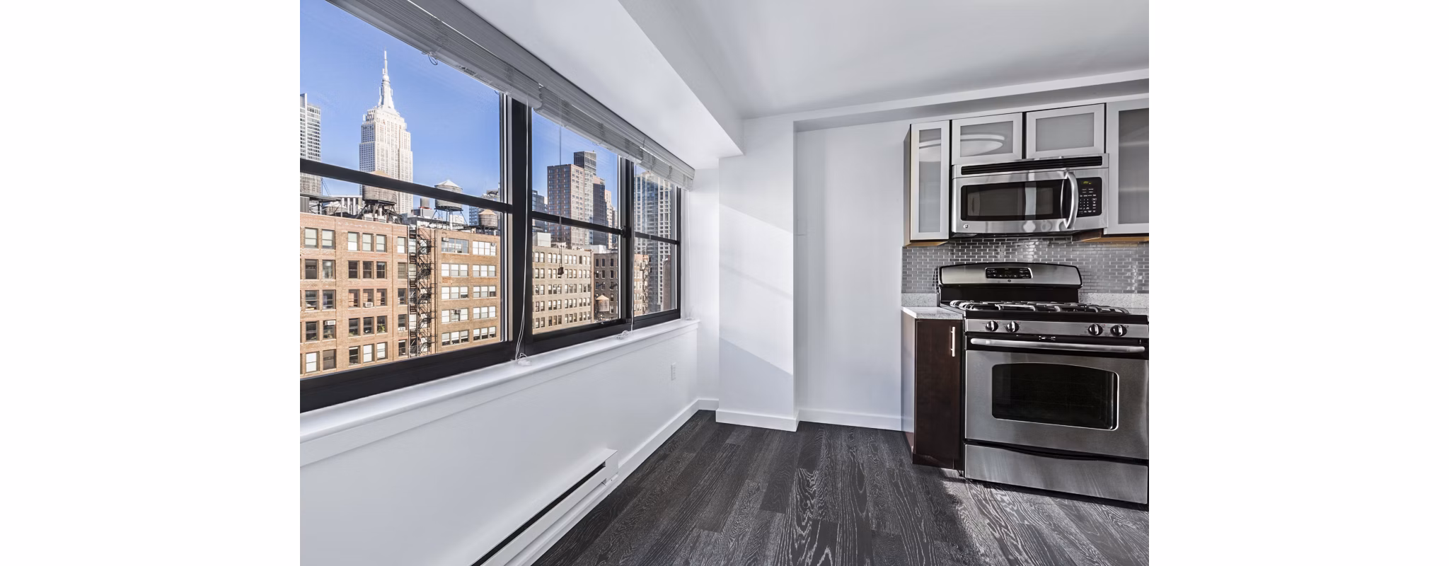 Bright kitchen with stainless steel appliances and city skyline view at The Chelsea Apartments