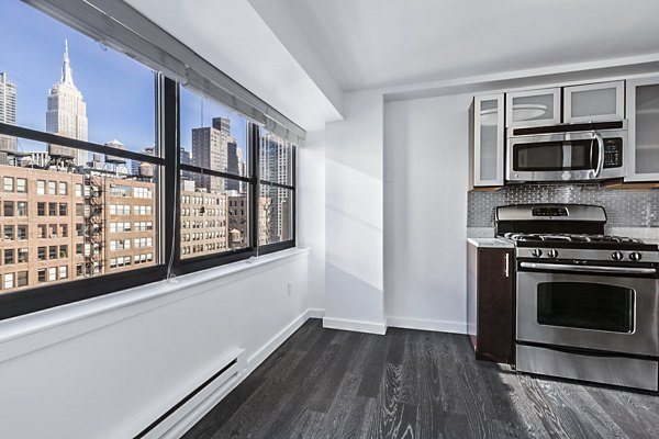 Bright kitchen with stainless steel appliances and city skyline view at The Chelsea Apartments