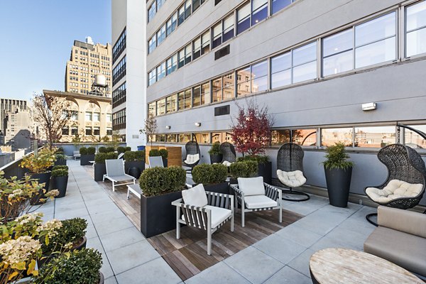 Rooftop patio with seating, plants, and city view at The Chelsea Apartments