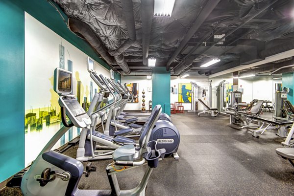 Fully-equipped fitness center at VUE25 Apartments with modern exercise machines and free weights