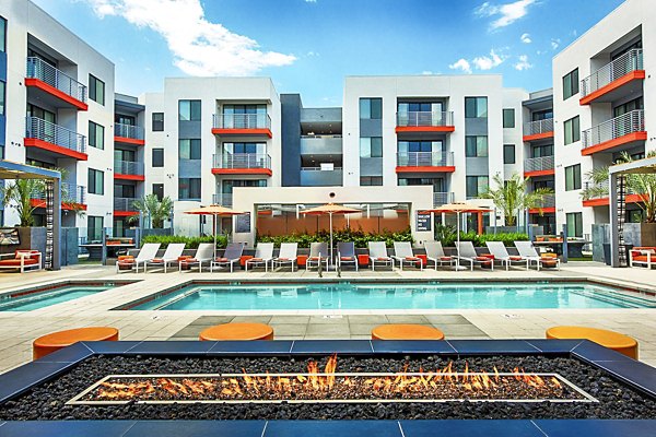 Modern outdoor pool with lounge chairs at The Tomscot Apartments in Scottsdale, ideal for relaxation and sunbathing