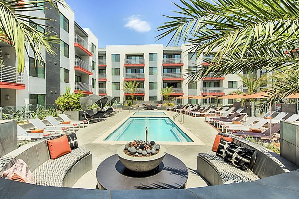 Stylish outdoor pool area with sun loungers at The Tomscot Apartments, offering luxury amenities in a vibrant community setting