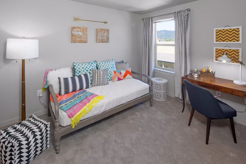 Cozy bedroom with natural light and modern decor at The Tennyson at Crescent Village Apartments
