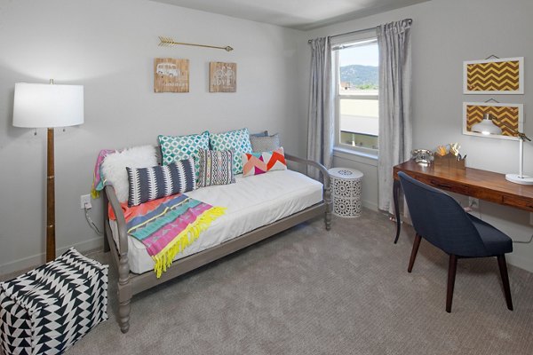 Cozy bedroom with natural light and modern decor at The Tennyson at Crescent Village Apartments