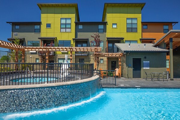 Outdoor pool with stylish seating at The Tennyson at Crescent Village Apartments, perfect for relaxation and social gatherings