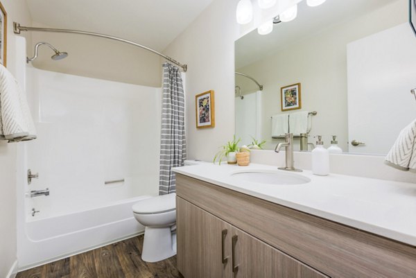 Modern bathroom with double vanity and marble countertops in Lineage at Willow Creek Apartments