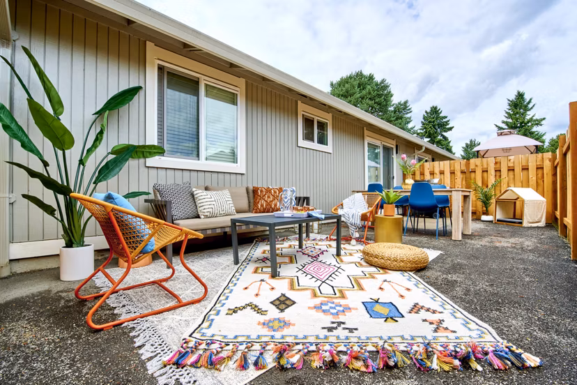 Patio area with cozy seating and greenery at Lineage at Willow Creek Apartments