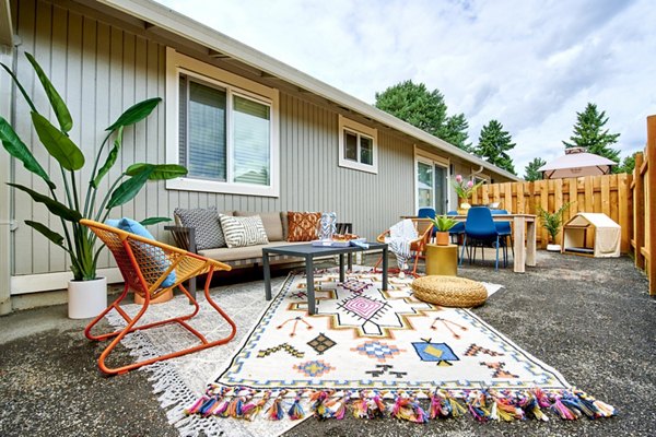 Patio area with cozy seating and greenery at Lineage at Willow Creek Apartments