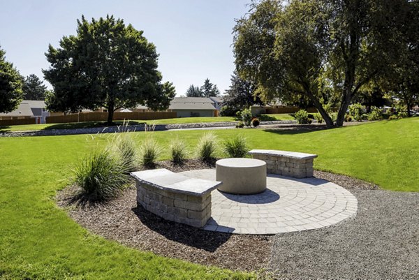 Lineage at Willow Creek: Serene courtyard area with lush greenery and seating, offering a tranquil outdoor retreat for residents to unwind