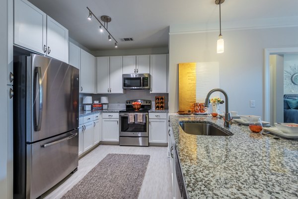 Modern kitchen with stainless steel appliances in Fountains Matthews Apartments