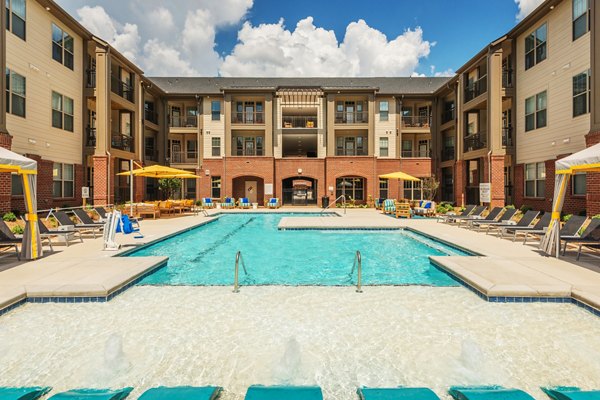 Resort-style outdoor pool at Fountains Matthews Apartments with lounge chairs and lush landscaping