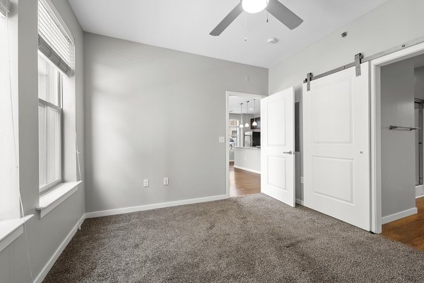 Modern bedroom featuring a cozy queen-size bed and chic decor at Confluence at Three Springs Apartments, showcasing luxury Greystar living