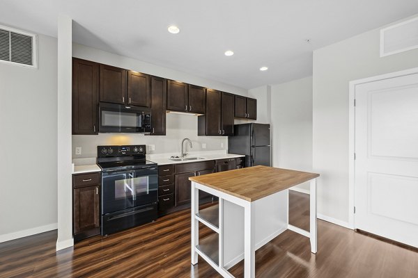 Modern kitchen with sleek countertops and stainless steel appliances in Confluence at Three Springs luxury apartments