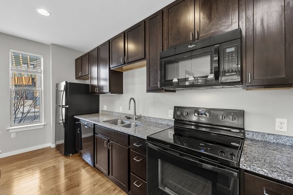 Modern kitchen with stainless steel appliances at Confluence at Three Springs Apartments