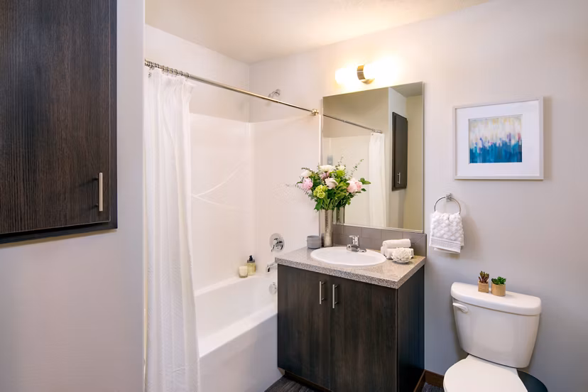 Modern bathroom with marble countertops and sleek fixtures in Jake at Indian Trail Apartments