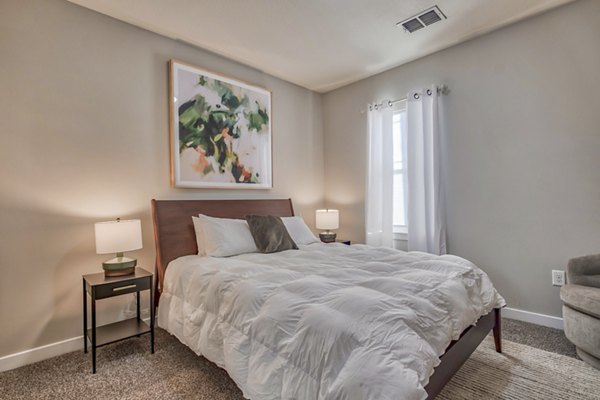 Chic bedroom with large windows and modern decor in River Oaks Apartments