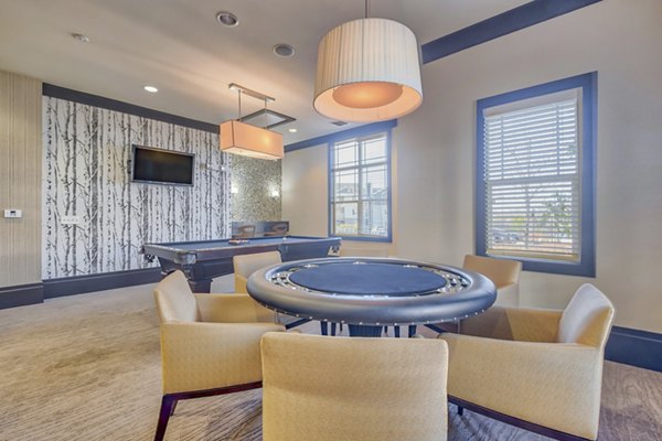 Game room with billiards table and lounge seating at River Oaks Apartments, offering recreational amenities for residents