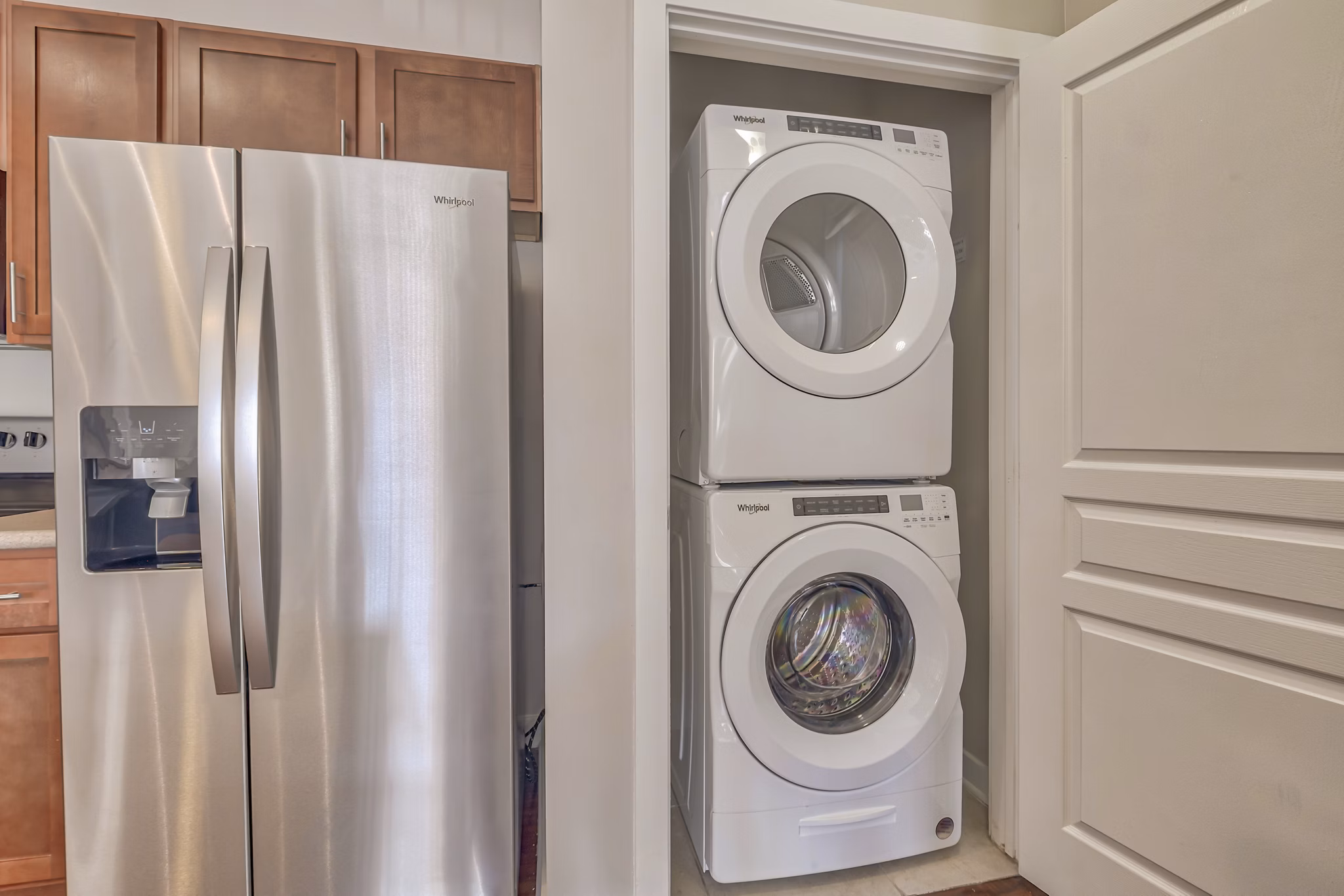 Laundry room with modern appliances and folding area in River Oaks Apartments