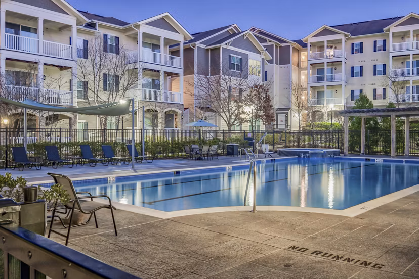 Poolside relaxation area featuring luxurious lounge chairs at River Oaks Apartments Experience leisure in an upscale setting next to the shimmering pool