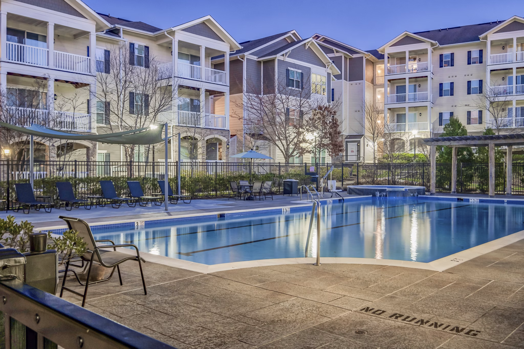 Poolside relaxation area featuring luxurious lounge chairs at River Oaks Apartments Experience leisure in an upscale setting next to the shimmering pool