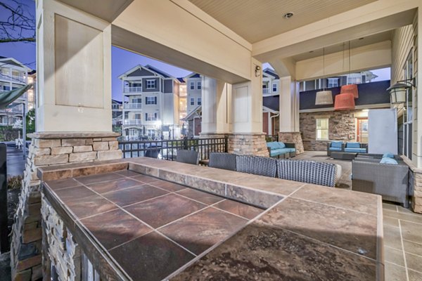 Charming outdoor patio with seating and greenery at River Oaks Apartments, perfect for relaxation and socializing in a serene setting