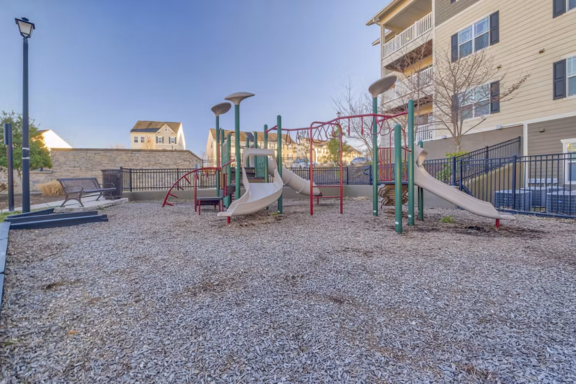 Colorful playground with slides and swings at River Oaks Apartments, perfect for family fun and outdoor activities