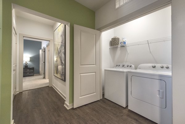 Laundry room featuring modern appliances at Eastbank at Waterside Apartments