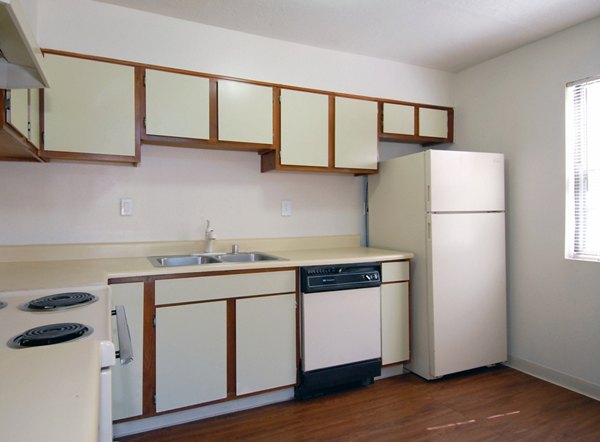 Modern kitchen with stainless steel appliances and granite countertops in Entrada Pointe Apartments