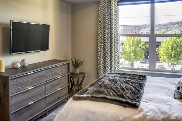 Modern bedroom featuring large windows and contemporary decor at Waterline Apartments in Portland, OR.